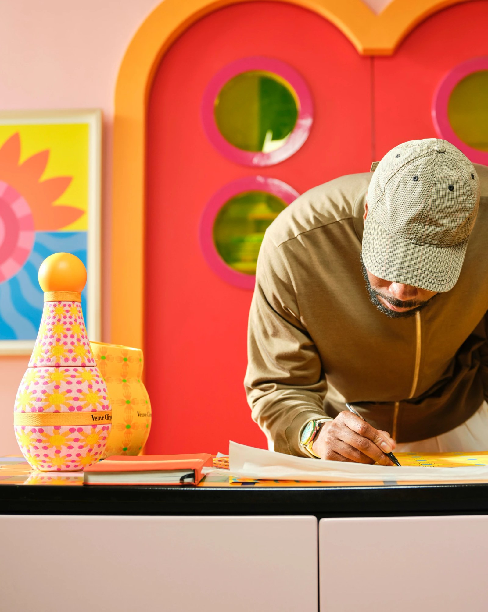 Lifestyle objects from the Veuve Clicquot x Yinka Ilori collection, including colorful trays and glasses.