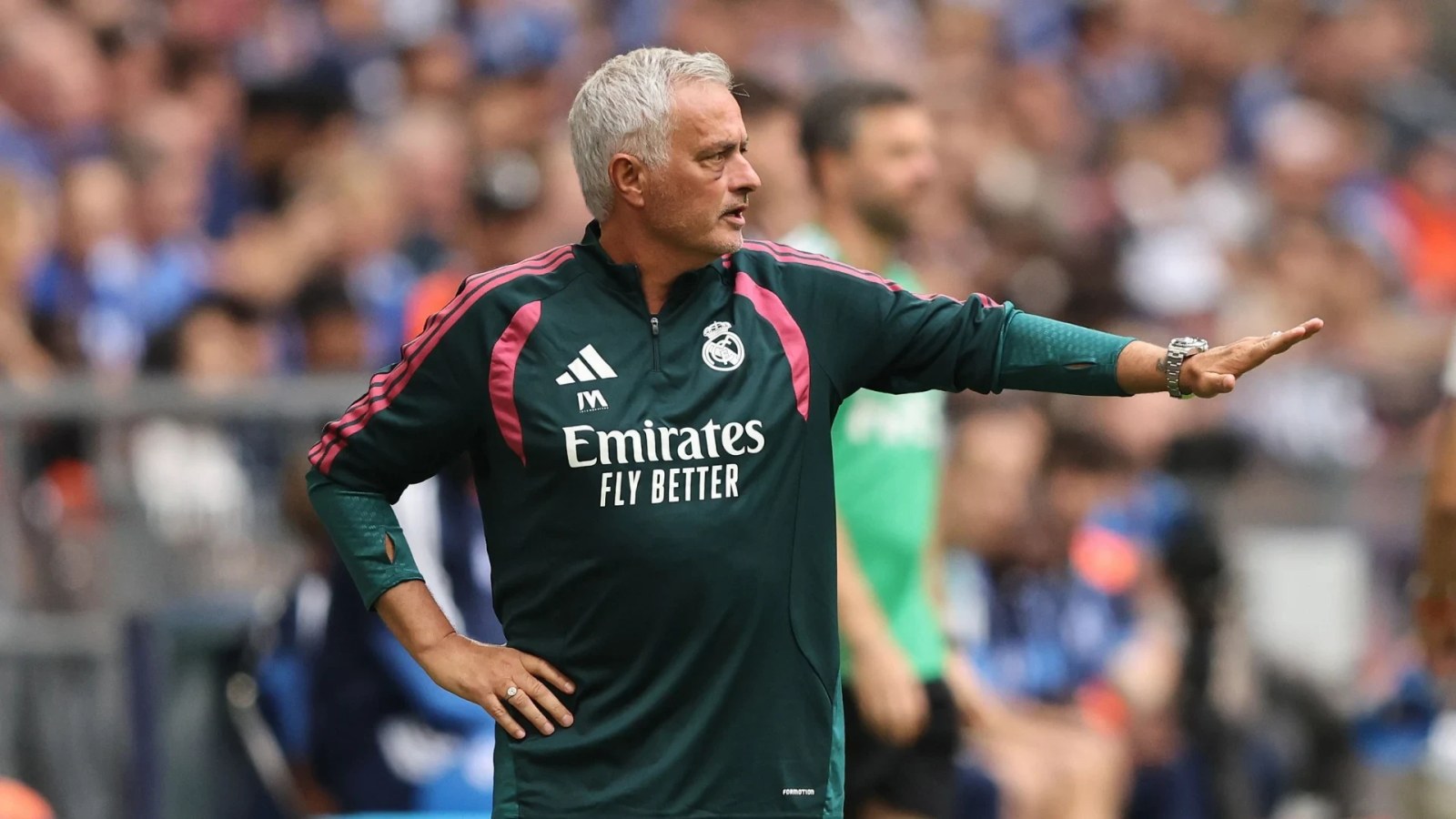José Mourinho looking thoughtful in formal attire.
