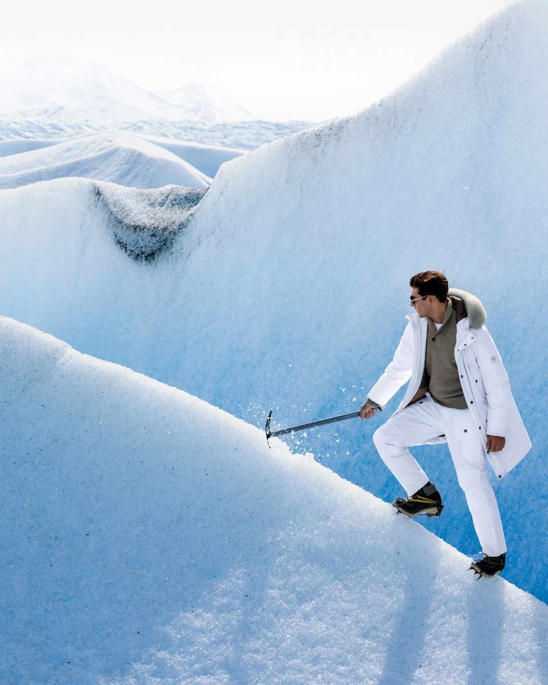 A model in Stefano Ricci clothing hiking on a glacier in Patagonia.