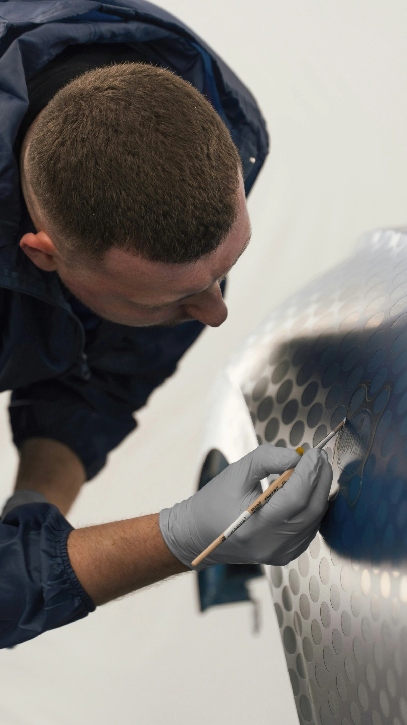 Close-up of the 'Fly Bug' script hand-painted on the rear wing of the Bugatti W16 Mistral.